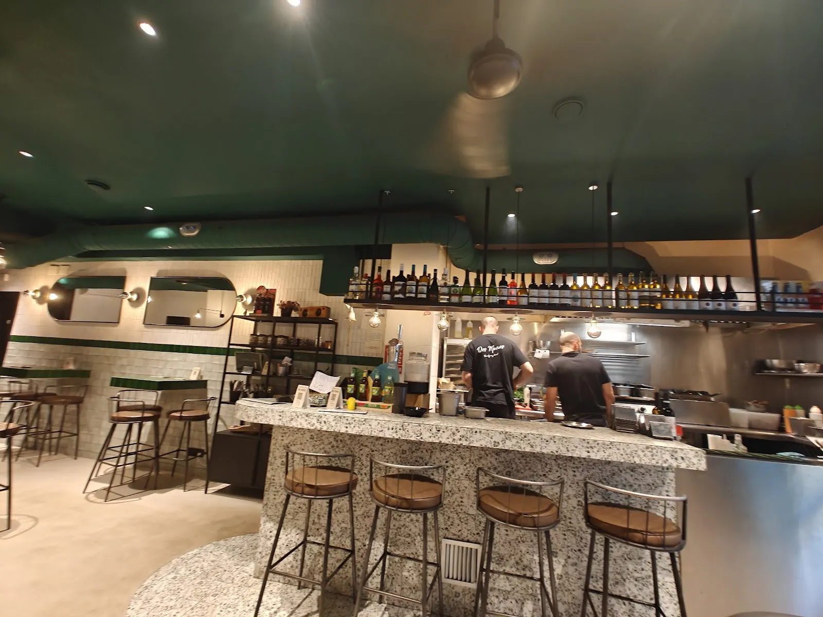 La barra de baldosas verdes y la cocina abierta