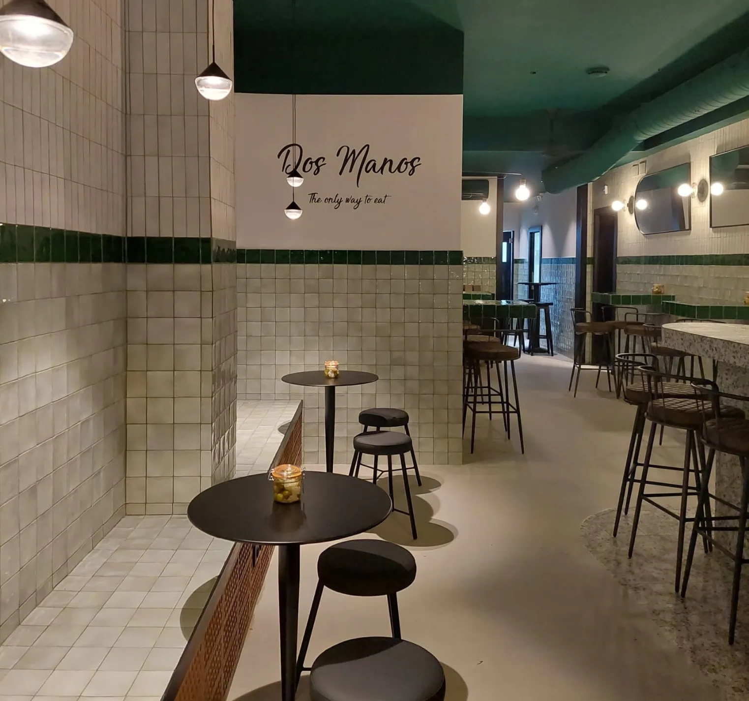 El interior de Dos Manos, con el letrero «Dos Manos — The only way to eat» en la pared