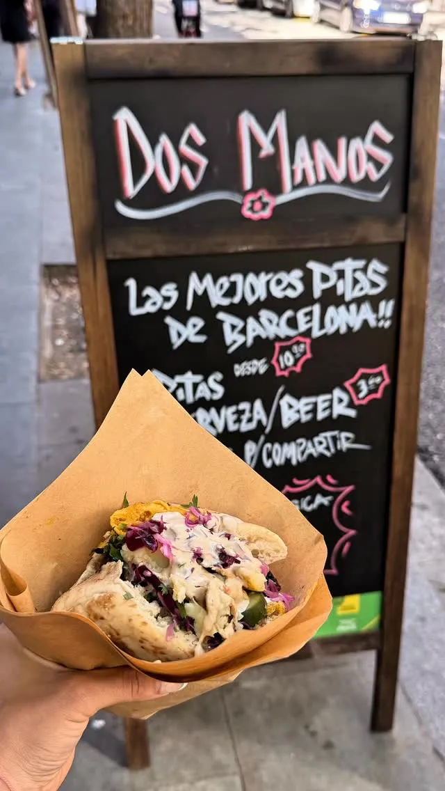 La pizarra de Dos Manos en la calle, con una pita